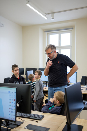 Naukowe Ferie w Pasażu Odkryć - Na zdjęciu przedstawieni są uczestnicy – dzieci i młodzież – zaangażowani w aktywności edukacyjne w różnych pracowniach naukowych, takich jak chemiczna, stolarska, planetarium oraz informatyczna. Widoczne są sceny, gdzie uczą się i przeprowadzają eksperymenty pod nadzorem instruktorów.