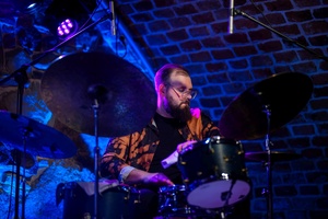 Koncert jazzowy: Kasia Pietrzio Trio - Artyści na scenie w trakcie koncertu - Piotr Budniak gra na perkusji