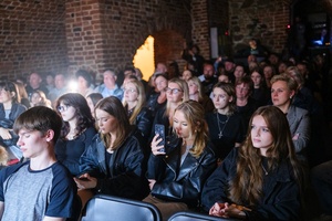 Koncert: Pracownia Piosenki "Na przekór" - Podczas koncertu. Publiczność siedzi i słucha.