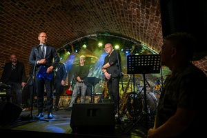 Benefis Bartka Szułakiewicza - Prezydent Tarnowa Jakub Kwaśny na scenie wręcza jubilatowi list gratulacyjny.