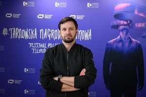 40. TNF: Dzień 7 (28.05.26) - W hallu Marzenia na ściance festiwalowej pozujący do zdjęcia reżyser Piotr Domalewski