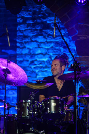 Koncert jazzowy - Bernard Maseli "The Nomads" - Paweł Dobrowolski gra na perkusji w niebieskim świetle.